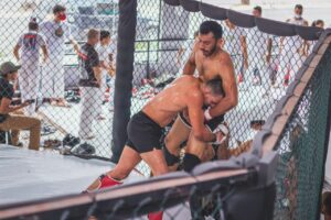 Due atleti durante un allenamento di wrestling vicino alle corde del ring